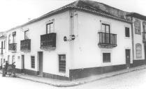 Reprodução de uma foto antiga de um edifício e de um autóctone da cidade de Angra do Heroísmo